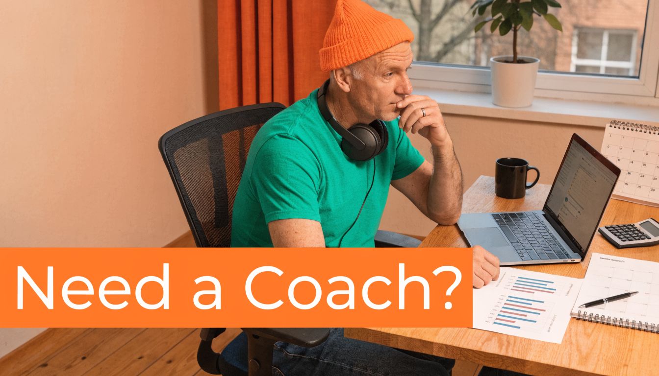 A professional man with an orange beanie working at a desk while consulting with a digital coach.